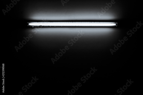 Detail of a fluorescent light tube mounted on a wall