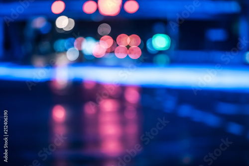 Cars driving on wet road in the rain and colored lights reflected on the wet asphalt road © Bob