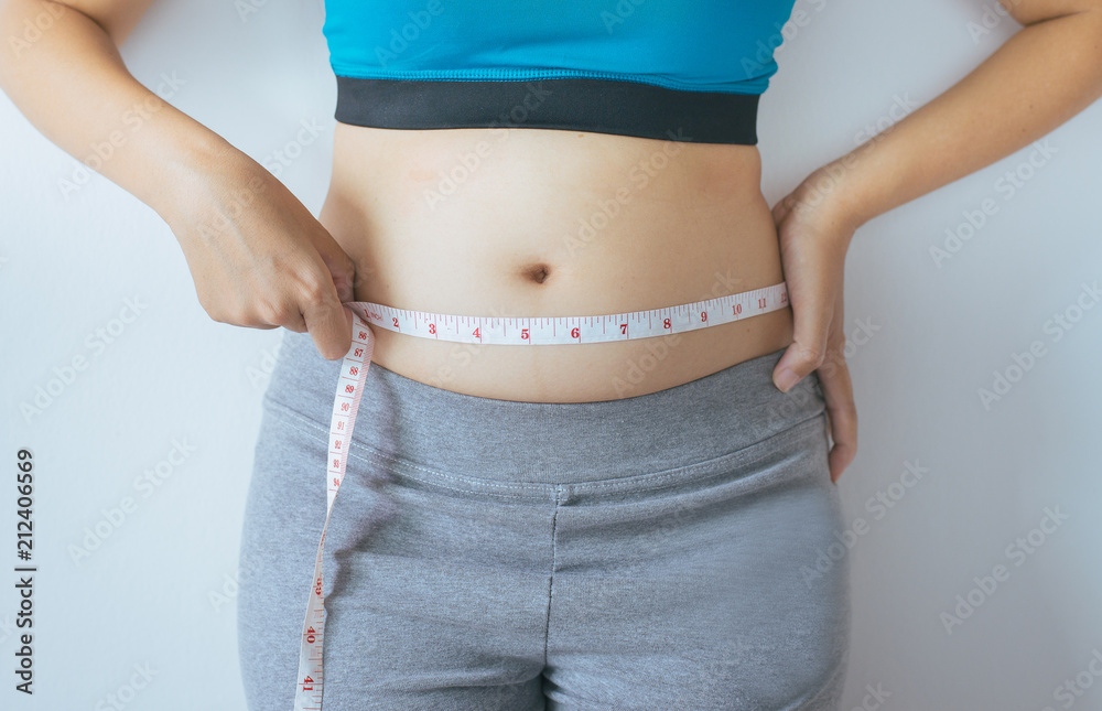Woman measuring waist with measuring tape,Excess belly fat and overweight  fatty bellys of female Stock Photo