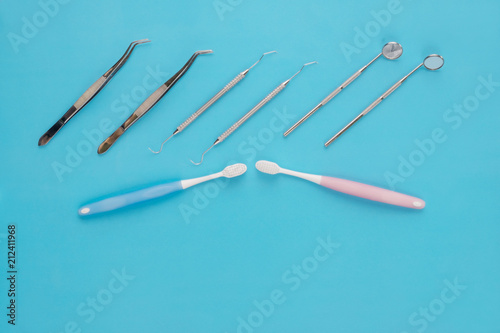 Dental tools use for dentist on the blue background, flat lay, top vipw.