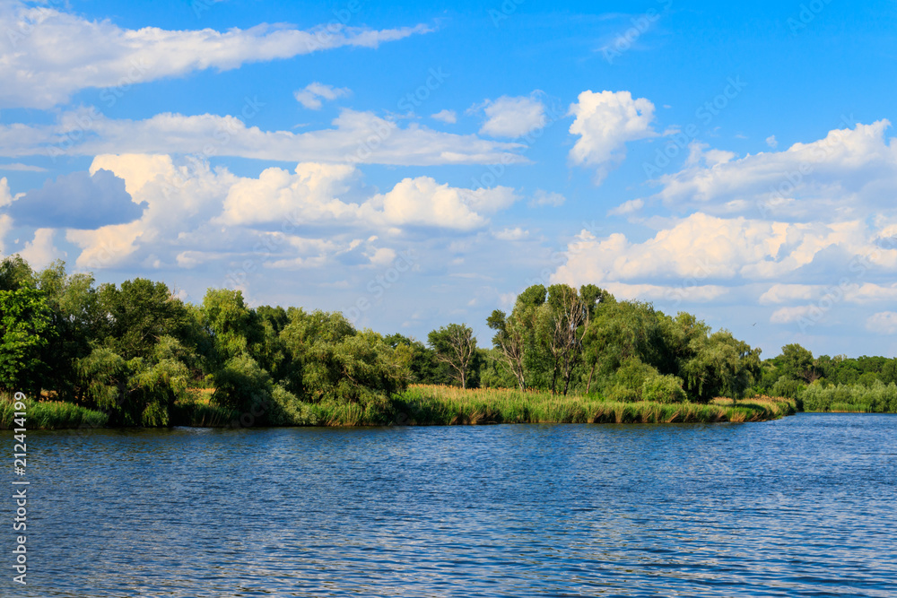 Summer landscape with beautiful lake, green trees and blue sky Summer landscape with beautiful lake, green trees and blue sky