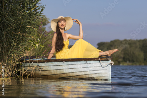 Attractive young woman with long brunette hair on a boat