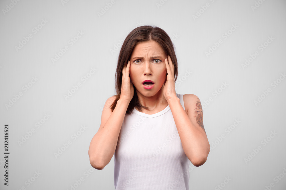 Horrible, stress, shock. Female half-length portrait isolated at gray studio. Young emotional surprised woman clasping head in hands. Human emotions, facial expression concept. Front Horrible, stress, shock. Female half-length portrait isolated at gray studio. Young emotional surprised woman clasping head in hands. Human emotions, facial expression concept. Front
