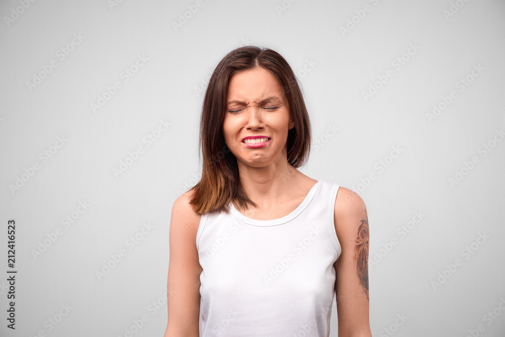 Portrait of displeased upset female frowns face as going to cry, being discontent and unhappy as cant achieve goals, isolated over gray studio background. Dissapointed young woman has troubles Portrait of displeased upset female frowns face as going to cry, being discontent and unhappy as cant achieve goals, isolated over gray studio background. Dissapointed young woman has troubles