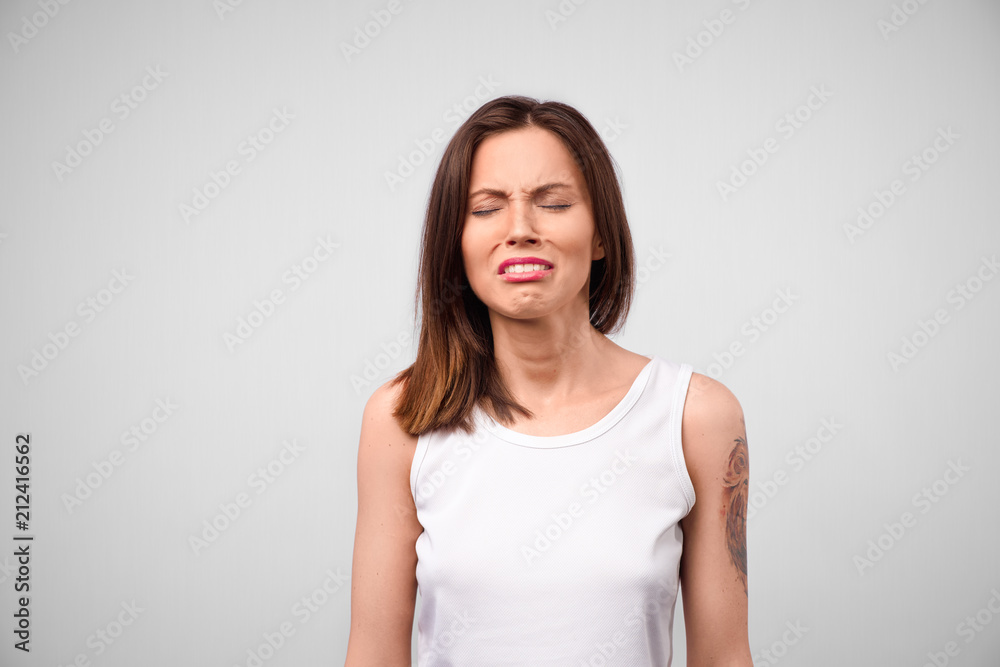 Desperate woman going to cry, has sorrorful expression, regrets her actions, makes big mistake or failure, frowns face. Miserable female poses in white studio, expresses negative emotions Desperate woman going to cry, has sorrorful expression, regrets her actions, makes big mistake or failure, frowns face. Miserable female poses in white studio, expresses negative emotions