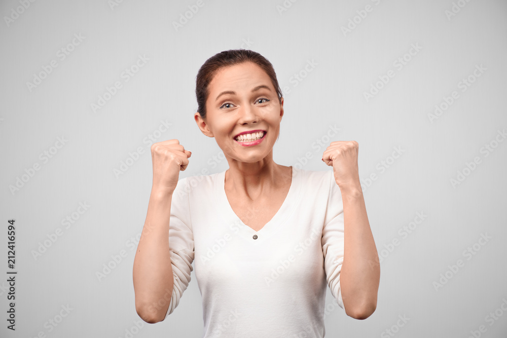 Surprised woman with hands up amazed or shocked by unexpected news holding close palms up and showing happy expression. Young adult woman on grey background Surprised woman with hands up amazed or shocked by unexpected news holding close palms up and showing happy expression. Young adult woman on grey background