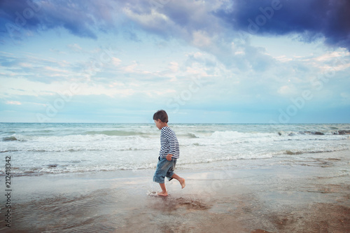 Child running on the beach. Summer vacation. happy kid playing on beach at the sunset time
