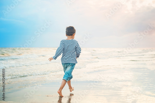 Child running on the beach. Summer vacation. happy kid playing on beach at the sunset time