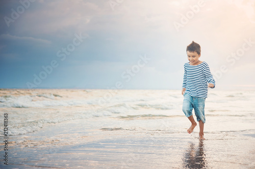 Child running on the beach. Summer vacation. happy kid playing on beach at the sunset time