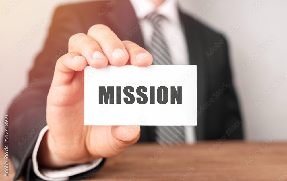 Businessman holding a card with text Mission Businessman holding a card with text Mission