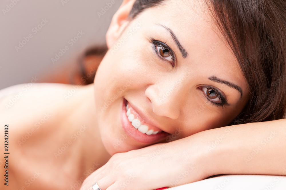 beautiful coy woman smiling on her sofa