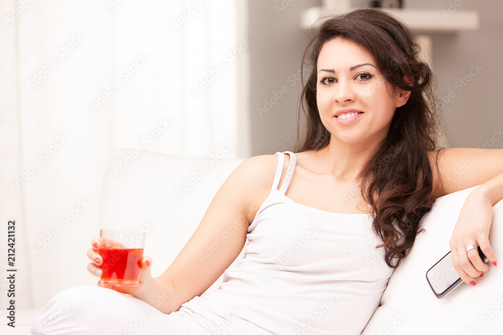 young woman drinking something in her living room young woman drinking something in her living room