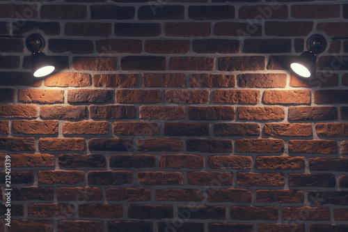 Old red brick wall with two spotlights. Rays in the center. Background texture closeup.