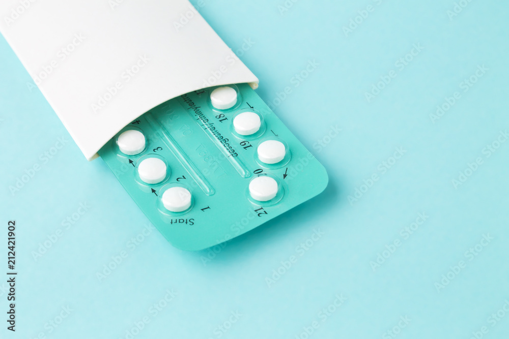 Pack of oral contraceptive pills with instructions. Blister in white case on blue background - obrazy, fototapety, plakaty 