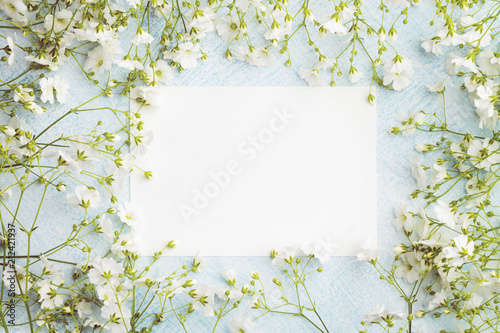 Photography Empty sheet of paper surrounded by small white flowers