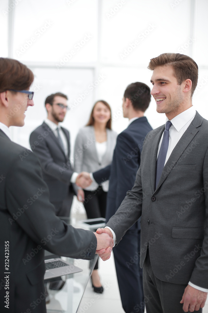 Two businessmen handshaking, congratulating on promotion. Two businessmen handshaking, congratulating on promotion.