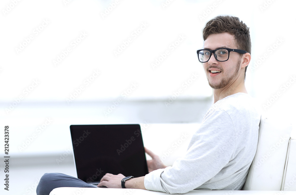 modern young man working on laptop sitting in the living room.