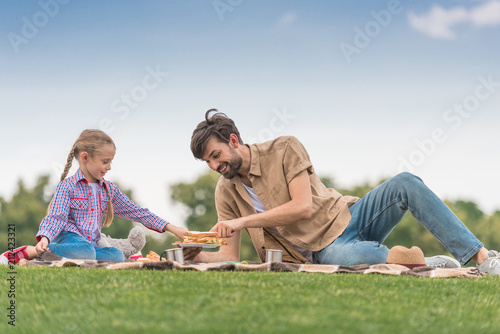 happy father and daughter spending time together at picnic in park