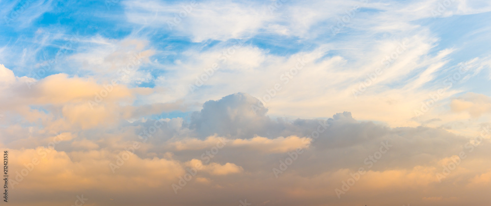 Panorama of cumulus clouds at sunset with gradient sky.