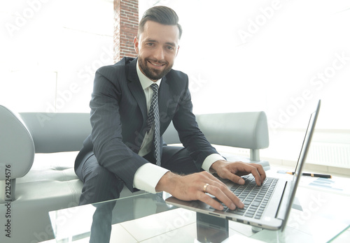 Successful man working on laptop in modern office