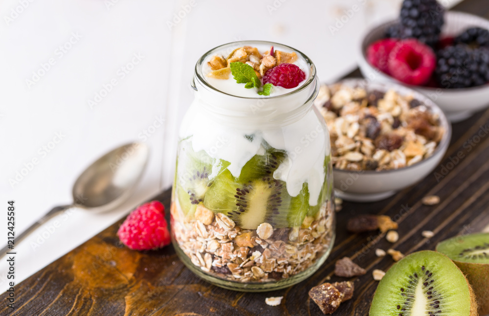 White yogurt with muesli in glass bowl on rustic wooden desk. White yogurt with muesli in glass bowl on rustic wooden desk.