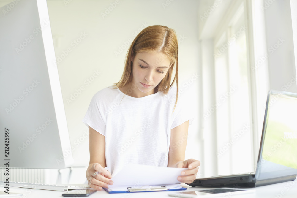Confident young businesswoman working at office desk. Home office Confident young businesswoman working at office desk. Home office