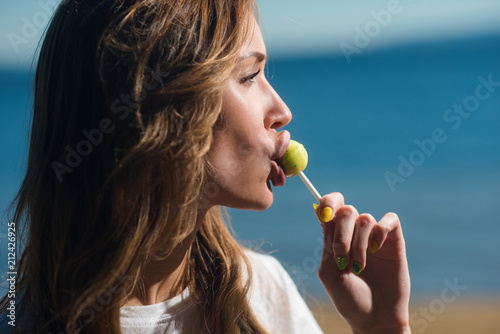 Beautiful girl sucks Lollipop in summer outdoors