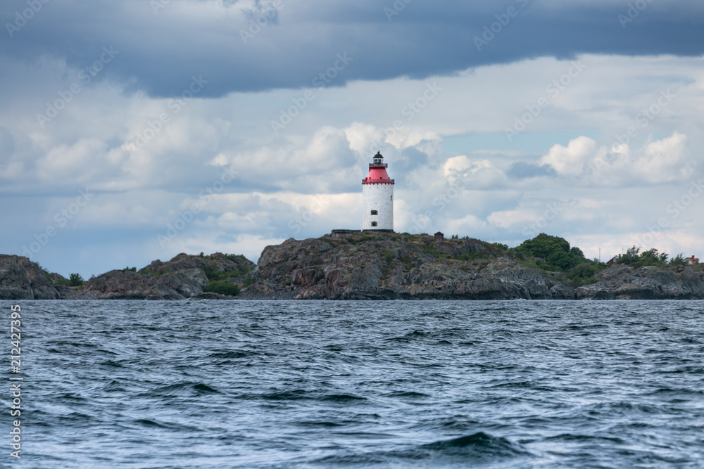 Scandinavian coastal landscape with lighthouse. Dramatic sky Scandinavian coastal landscape with lighthouse. Dramatic sky