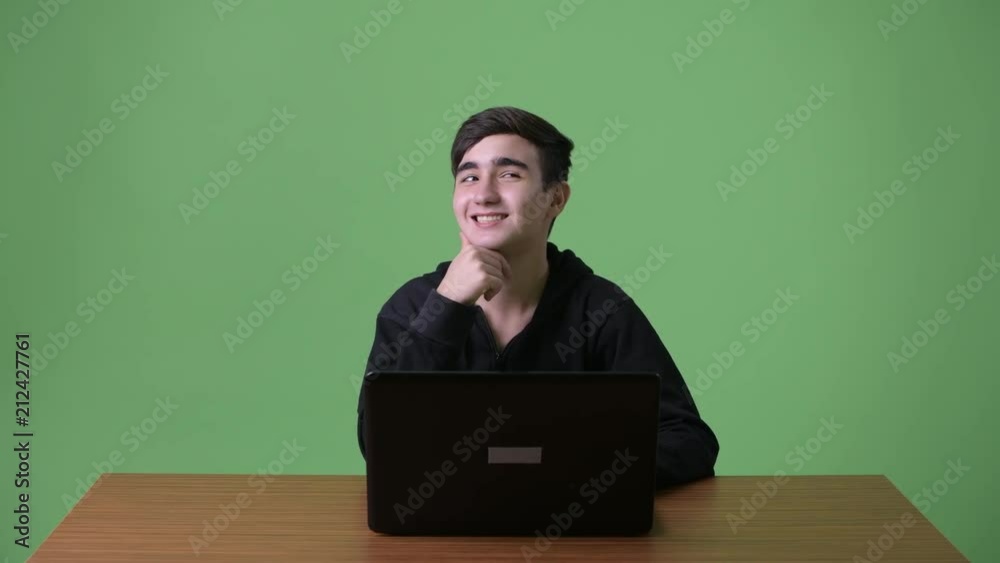 Young handsome Iranian teenage boy against green background Young handsome Iranian teenage boy against green background