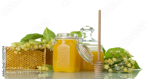 Two pots with honey, wooden spoon and honeycomb isolated on white