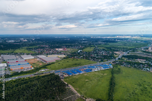 Aerial view of wheat fields, meadow, forest and village in rural Russia.