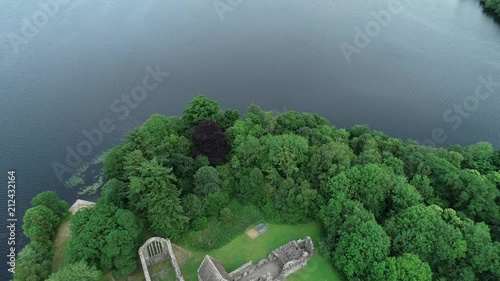 Aerial footage over the ruins of Inchmahome Priory on a tree covered island on the picturesque Lake of Menteith. photo