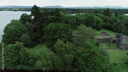 Aerial footage over the ruins of Inchmahome Priory on a tree covered island on the picturesque Lake of Menteith. photo