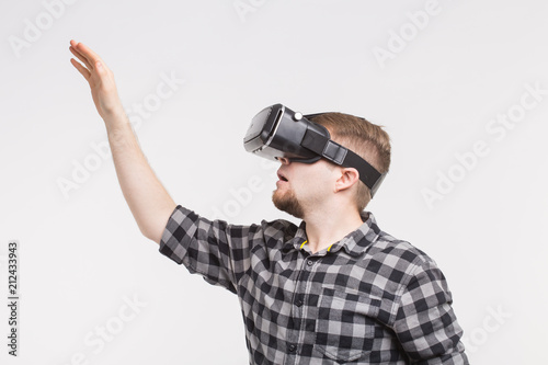 Man wearing virtual reality glasses raising his hand