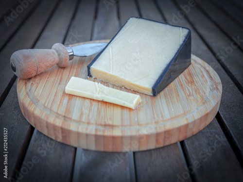 English barber cheddar in black wax. Cheese board and cheese knife. Wooden. photo