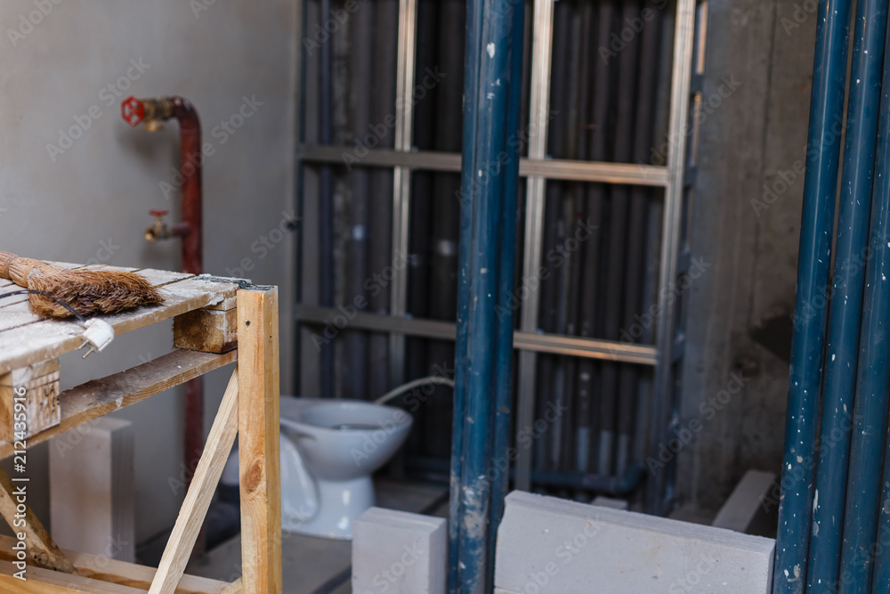 Repair in the apartment. Construction grunge ladder in white interior, of a bright room with fresh plastered walls. White walls in a building construction house.