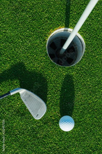 Golf ball on the green course. Close up. Top view. Sport, relax, recreation and leisure concept
