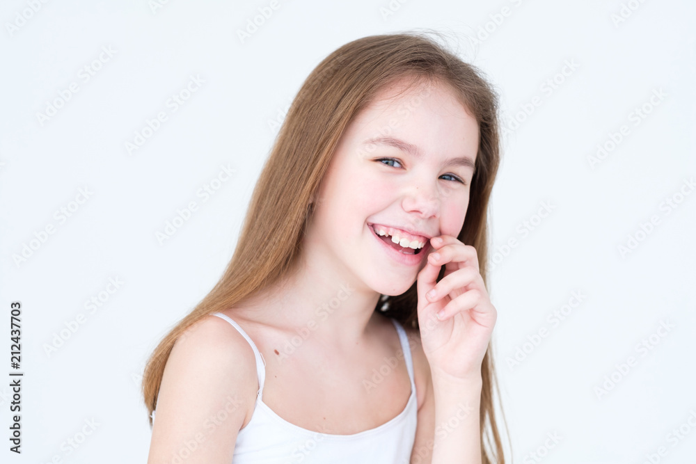 emotion face. happy child with playful and frolic smile. little girl portrait on white background. mood feelings personality and facial expression concept emotion face. happy child with playful and frolic smile. little girl portrait on white background. mood feelings personality and facial expression concept
