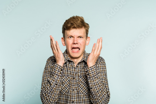 wtf. uncomprehending bewildered puzzled perplexed confused man gasping in wonder. portrait of a young guy on light background. emotion facial expression. feelings and people reaction.