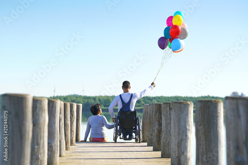 Frau und Mann im Rollstuhl am See
