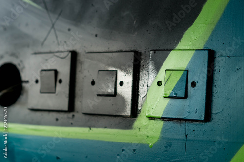 Drei Lichtschalter mit Graffitis übermalt