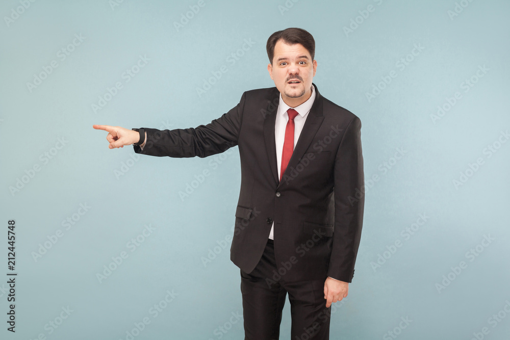 You're fired, this was the last mistake. indoor studio shot. isolated on light blue background. handsome businessman with black suit, red tie and mustache looking at camera. You're fired, this was the last mistake. indoor studio shot. isolated on light blue background. handsome businessman with black suit, red tie and mustache looking at camera.