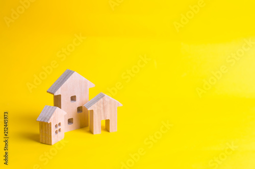 Three houses on a yellow background. Buying and selling of real estate, construction. Apartments and apartments. City, settlement. Minimalism. for presentations. real estate market. photo