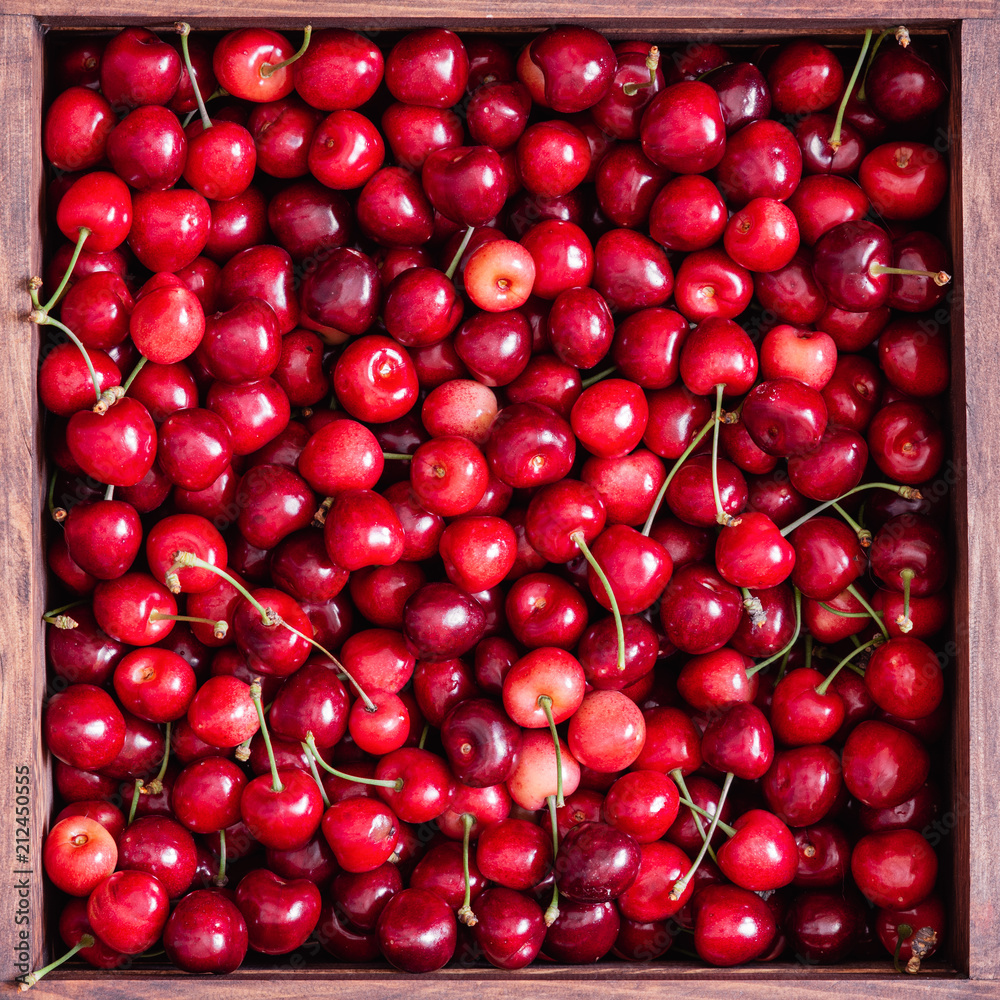 Sweet cherries in the wooden box on the wooden table Sweet cherries in the wooden box on the wooden table