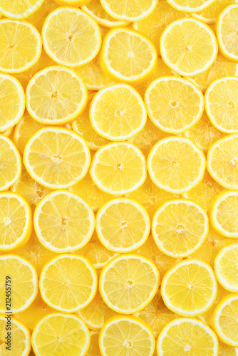 A slices of fresh juicy yellow lemons.  Texture background, pattern.