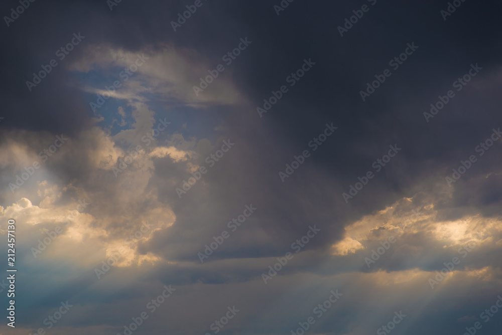 Obraz premium Rays of light break through layers of storm clouds