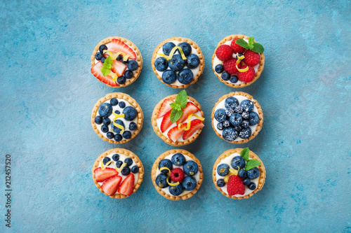 Set of different tartlets or cake with cream cheese and summer berry. Pastry dessert top view.