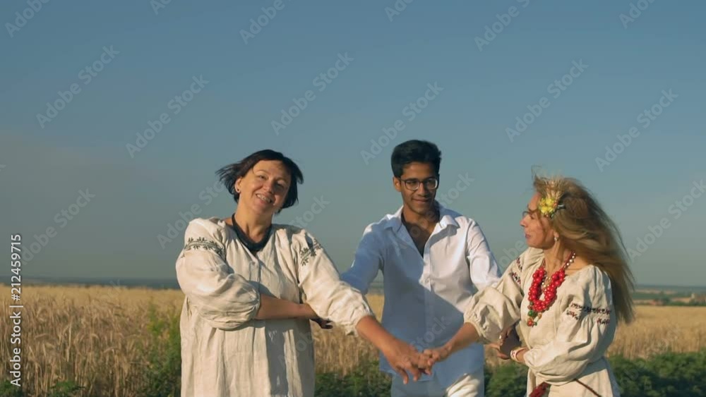 Slow Motion, Indian Boy in Points Together with Two Women in National Clothes Perform a National Dance on the Road Near the Wheat Field Slow Motion, Indian Boy in Points Together with Two Women in National Clothes Perform a National Dance on the Road Near the Wheat Field