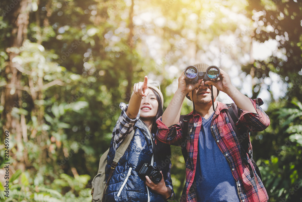 Lovers young with Binoculars and camera in rain Forest, Travel concept, Hiking concept. Lovers young with Binoculars and camera in rain Forest, Travel concept, Hiking concept.