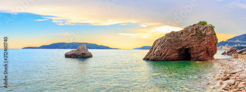 Sunset on the Adriatic sea near Budva city in Montenegro, gorgeous seascape with big rock in the beach photo